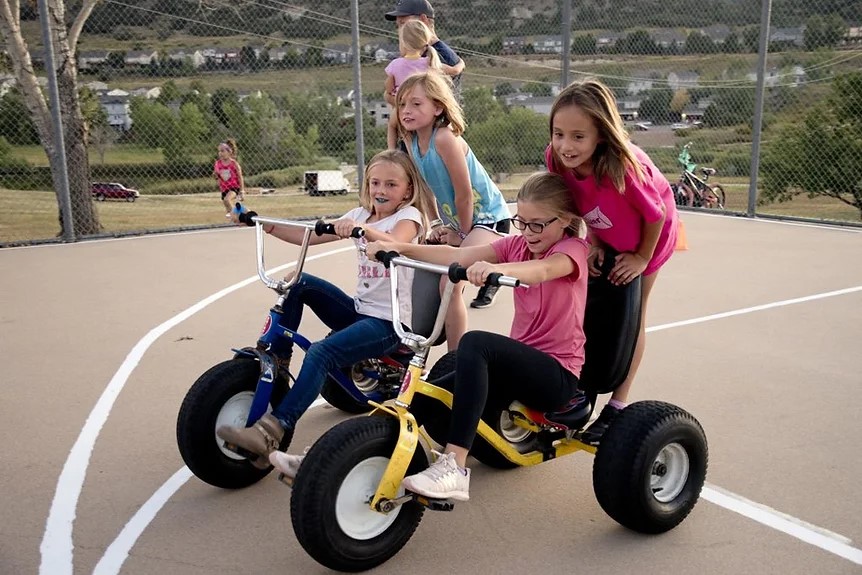 Children riding tricycle.